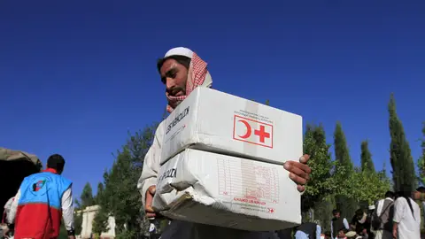 Afgano con cajas de ayuda de la Cruz Roja Afgano con cajas de ayuda de la Cruz Roja.