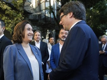 El presidente de la Generalitat, Carles Puigdemont, conversa con la alcaldesa de Barcelona, Ada Colau