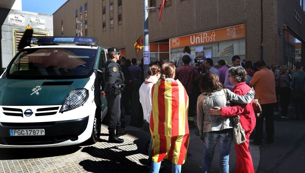 Numerosas personas permanecen ante la oficina de la empresa de mensajería Unipost en Terrassa
