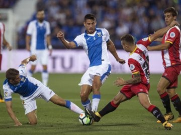 Szymanowski y Pires disputan el balón durante el Leganés - Girona