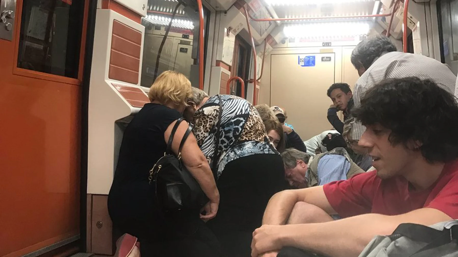 Los pasajeros se agachan dentro del vagón de metro Los pasajeros se agachan dentro del vagón de metro
