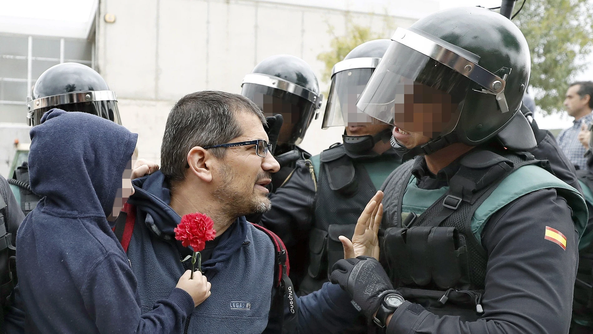 Un padre con su hijo en brazo conversa con un guardia civil ante uno de los colegios Un padre con su hijo en brazo conversa con un guardia civil ante uno de los colegios