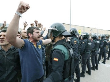 Un manifestante prorreferéndum se encara con un agente y alza el puño