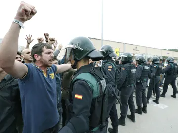 Un manifestante prorreferéndum se encara con un agente y alza el puño Un manifestante prorreferéndum se encara con un agente y alza el puño