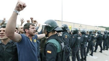 Un manifestante prorreferéndum se encara con un agente y alza el puño
