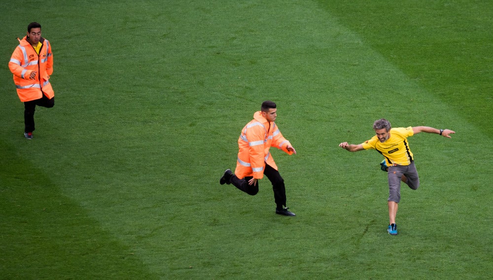 Un aficionado sortea el placaje de un miembro de seguridad en el partido del Barça a puerta cerrada