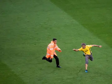 Un aficionado sortea el placaje de un miembro de seguridad en el partido del Barça a puerta cerrada Un aficionado sortea el placaje de un miembro de seguridad en el partido del Barça a puerta cerrada