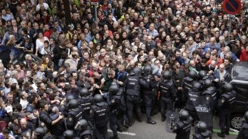 Antidisturbios de la Policía Nacional forman un cordón de seguridad en los alrededores del colegio Ramón Llull de Barcelona