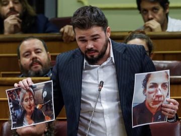 El portavoz de ERC, Gabriel Rufián, muestra unas fotografías durante su intervención