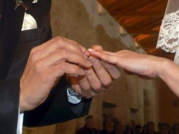 Manos de una pareja intercambiando los anillos en la ceremonia de su boda