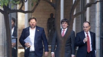 Carles Puigdemont, president de la Generalitat, entre el vicepresident, Oriol Junqueras, y el portavoz del Govern, Jordi Turull