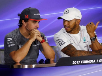 Fernando Alonso y Lews Hamilton dialogan durante el GP de Singapur