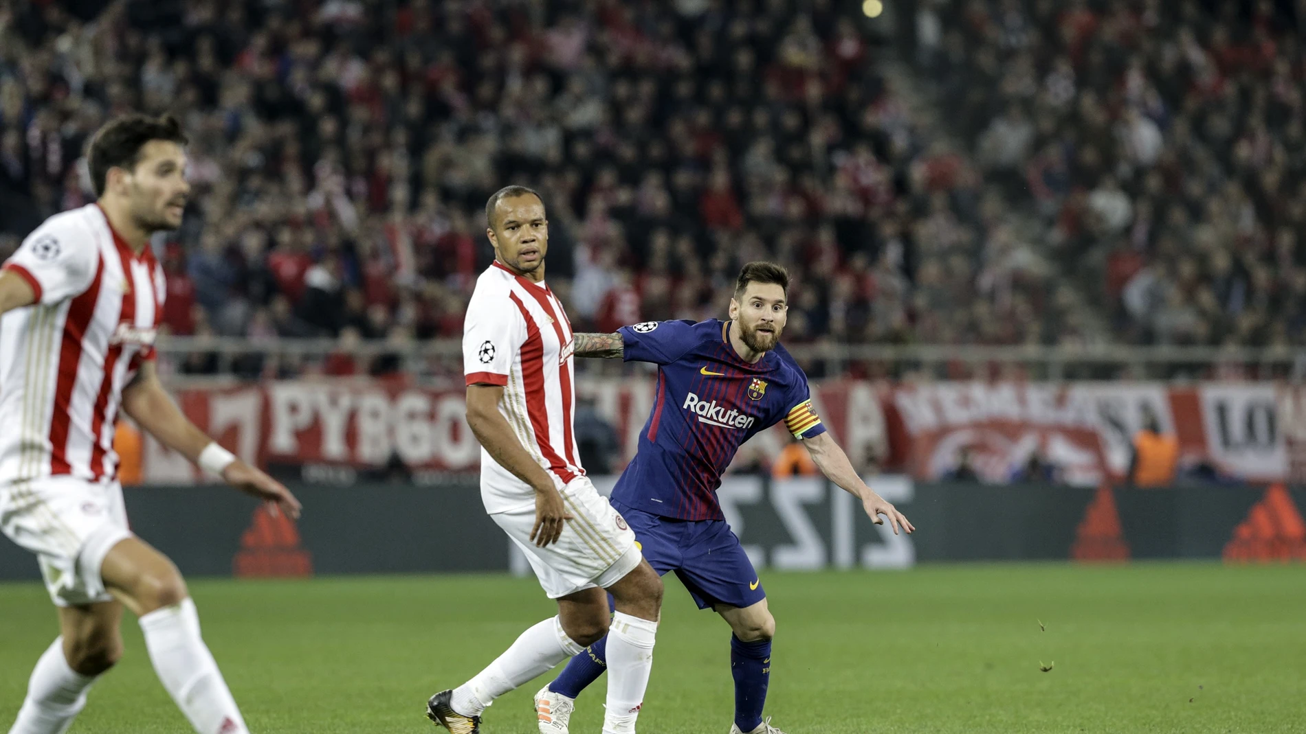 Messi dispara a puerta ante los defensas del Olympiacos