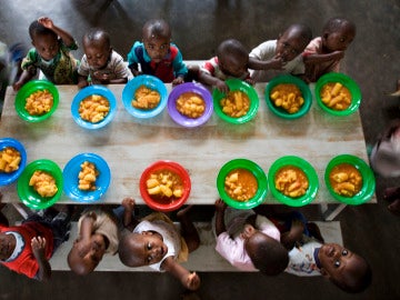 Varios niños huérfanos cenan en un orfanato
