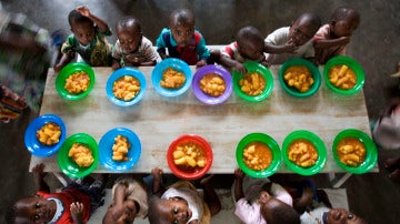 Varios niños huérfanos cenan en un orfanato