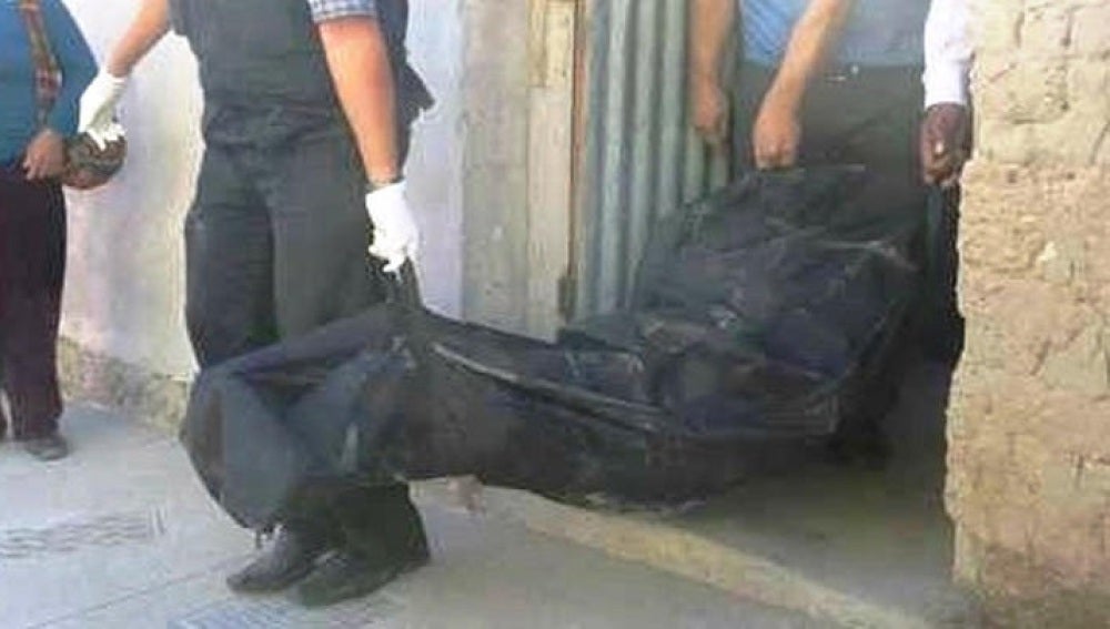 Los agentes llevándose el cuerpo de la mujer