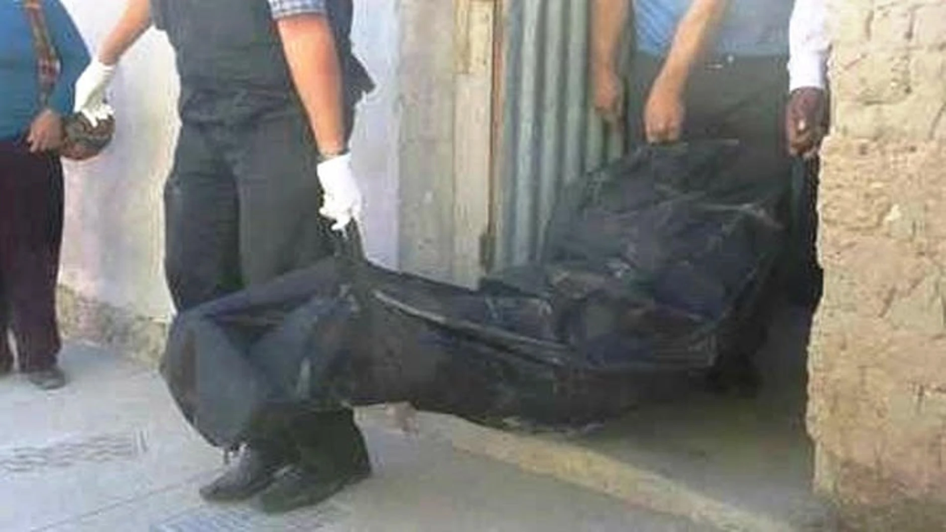 Los agentes llevándose el cuerpo de la mujer Los agentes llevándose el cuerpo de la mujer