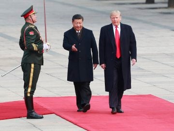 El presidente estadounidense Donald Trump (d) es recibido por su homólogo de China Xi Jinping (c) 
