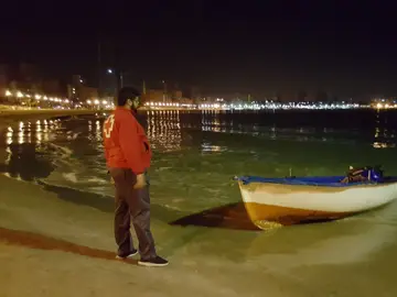 Un trabajador de la Cruz Roja frente a la patera Un trabajador de la Cruz Roja frente a la patera