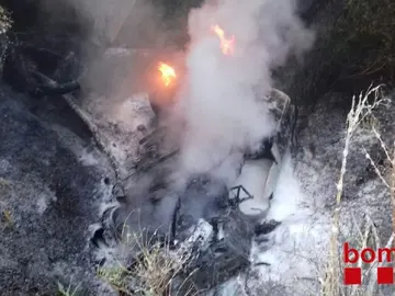 El camión incendiado tras caer por un puente El camión incendiado tras caer por un puente
