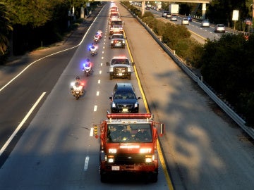 Comitiva de vehículos de bombero transportando el cuerpo del compañero fallecido