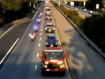 Comitiva de vehículos de bombero transportando el cuerpo del compañero fallecido Comitiva de vehículos de bombero transportando el cuerpo del compañero fallecido