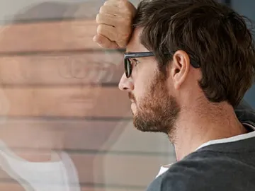 Imagen de archivo de un hombre mirando por la ventana Imagen de archivo de un hombre mirando por la ventana