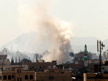 Una columna de humo se eleva hacia el cielo desde un almacén de armas de rebeldes hutíes en Saná, Yemen