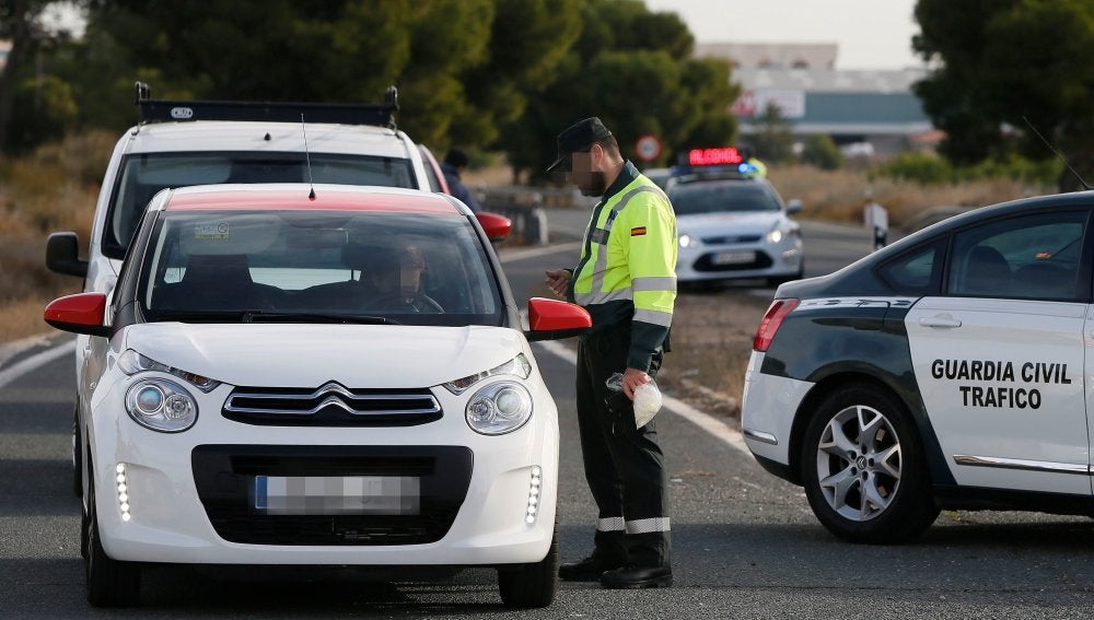 Un agente de la Guardia Civil da el alto a un vehículo en un control de tráfico