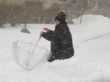 Una mujer camina en medio de nieve durante una tormenta de nieve