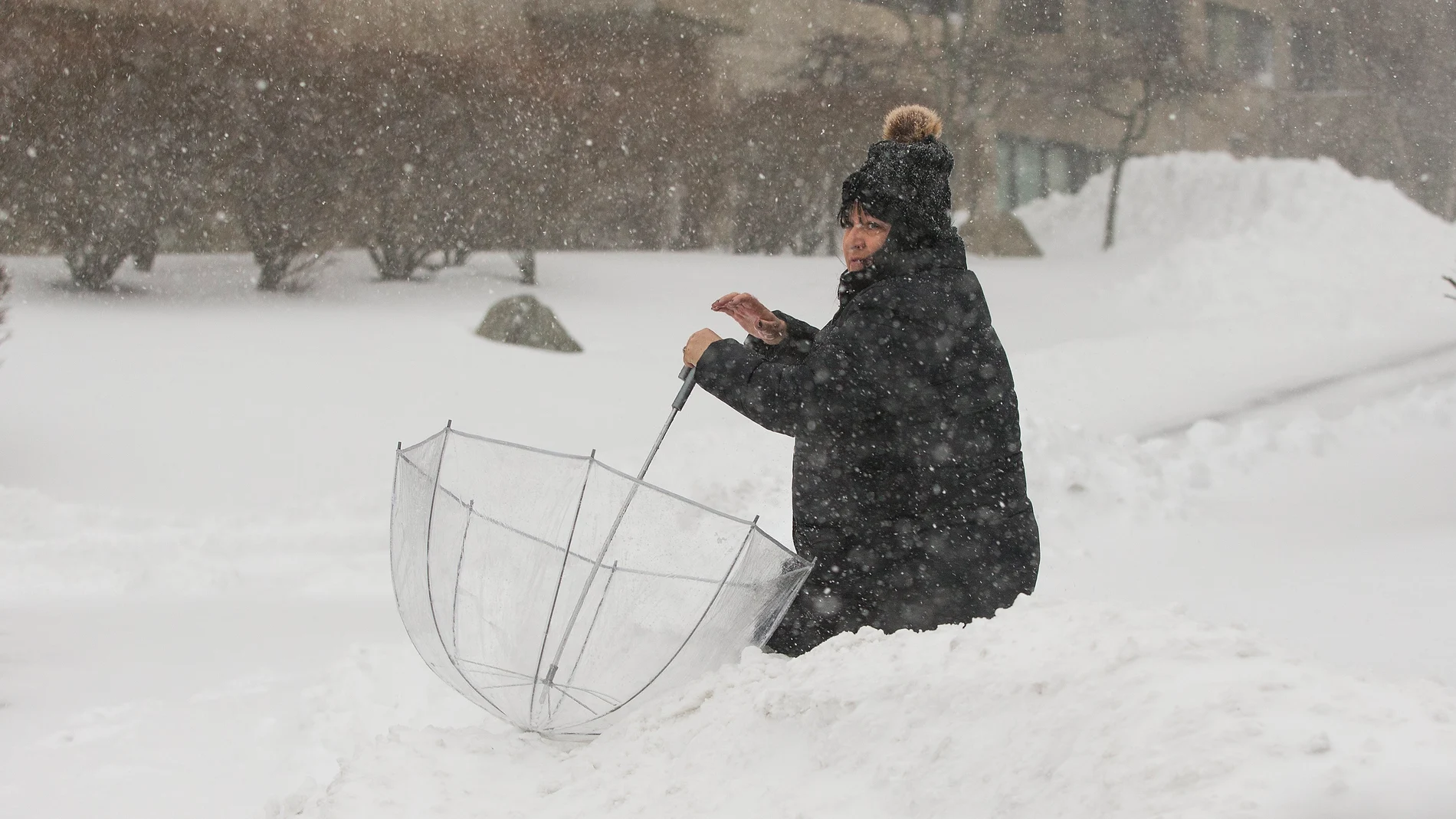 Una mujer camina en medio de nieve durante una tormenta de nieve Una mujer camina en medio de nieve durante una tormenta de nieve