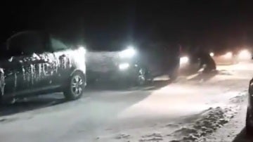 Vehículos detenidos en una carretera nevada