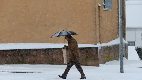 Un hombre camina bajo la nieve en la localidad salmantina de Guijuelo Un hombre camina bajo la nieve en la localidad salmantina de Guijuelo