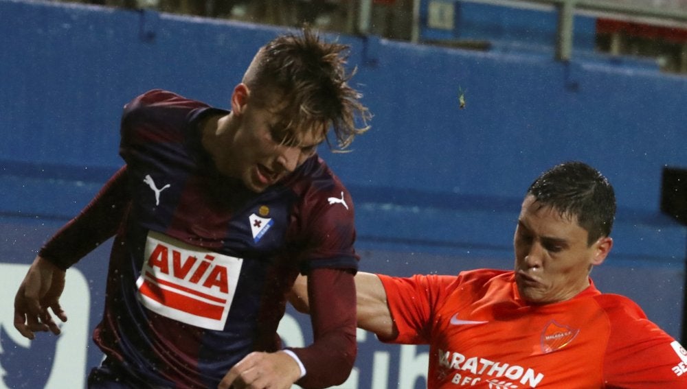Ricca e Iván Alejo luchan por la posesión del esférico durante el Eibar - Málaga