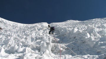 Unos montañeros escalando en la nieve