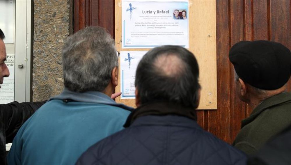 Vecinos de los fallecidos, observan la esquela de los dos ancianos encontrados muertos con signos de violencia