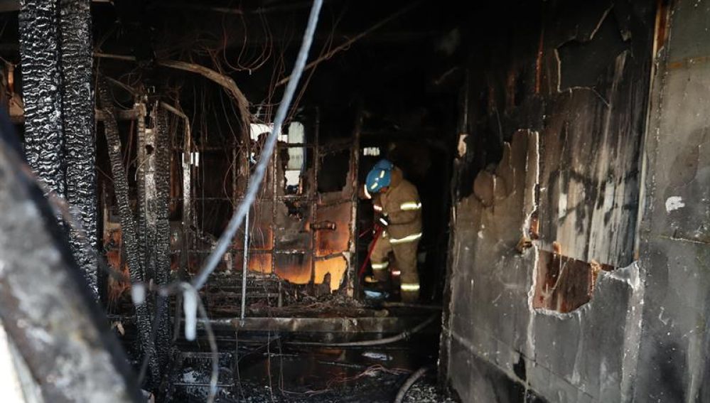 Bomberos apagan los restos del fuego en un cuarto de hospital Sejong