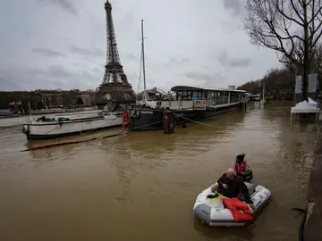 Un hombre transporta a un pasajero en un bote en el desbordado río Sena Un hombre transporta a un pasajero en un bote en el desbordado río Sena