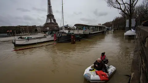 Un hombre transporta a un pasajero en un bote en el desbordado río Sena Un hombre transporta a un pasajero en un bote en el desbordado río Sena