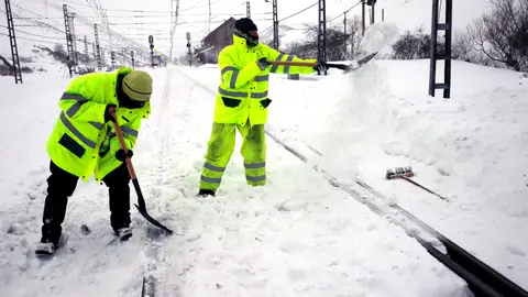 Dos operarios retiran la nieve en la estación de ferrocarril de Busdongo Dos operarios retiran la nieve en la estación de ferrocarril de Busdongo