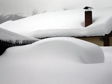Un vehículo cubierto de nieve, en el pueblo asturiano de Pajares Un vehículo cubierto de nieve, en el pueblo asturiano de Pajares