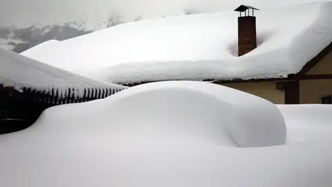 Un vehículo cubierto de nieve, en el pueblo asturiano de Pajares Un vehículo cubierto de nieve, en el pueblo asturiano de Pajares