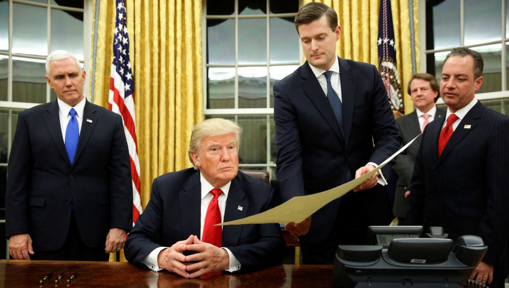 Rob Porter, secretario personal de la Casa Blanca, sujeta un documento a Donald Trump