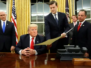 Rob Porter, secretario personal de la Casa Blanca, sujeta un documento a Donald Trump Rob Porter, secretario personal de la Casa Blanca, sujeta un documento a Donald Trump