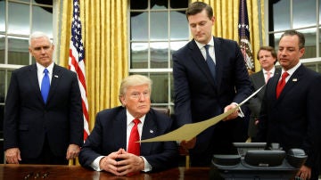 Rob Porter, secretario personal de la Casa Blanca, sujeta un documento a Donald Trump
