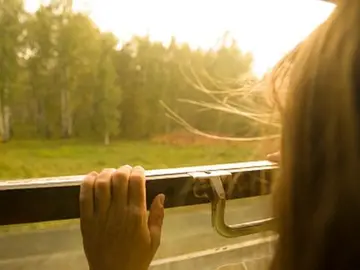 Una niña viajando en tren Una niña viajando en tren