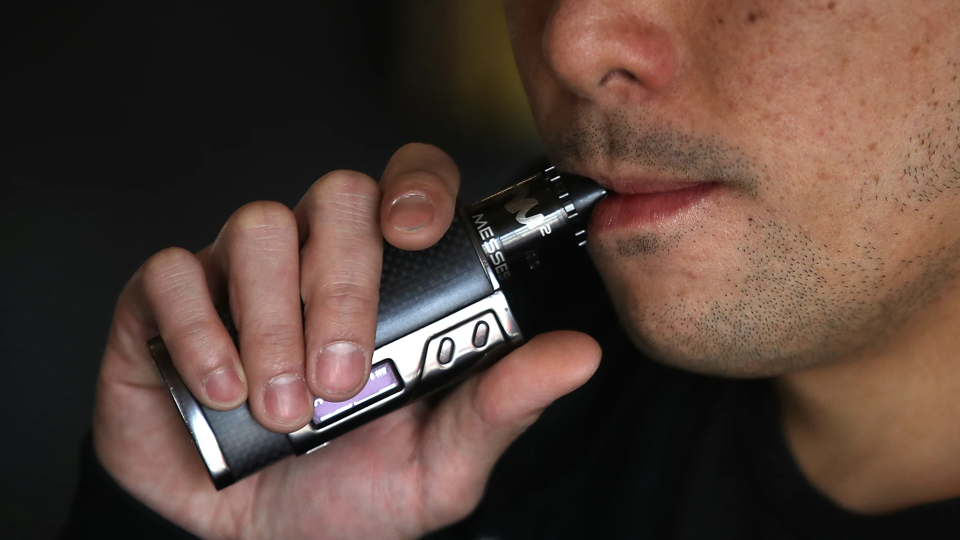 Un hombre fumando de un cigarro electrónico Un hombre fumando de un cigarro electrónico
