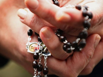 Una mujer con un rosario en las manos