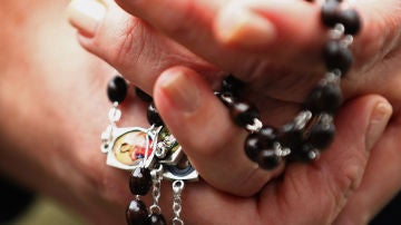 Una mujer con un rosario en las manos