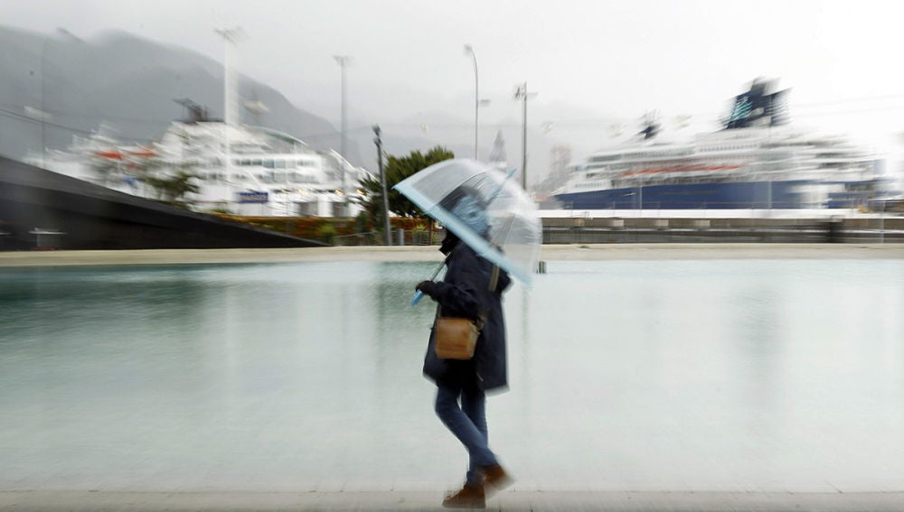 Una mujer paseando bajo la lluvia